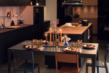 Una mesa festiva en una cocina negra y rosa