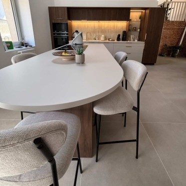 Cuisine sur mesure en noyer réalisée par Mobalpa Mâcon, avec meubles en bois, plan de travail assorti et finitions contemporaine